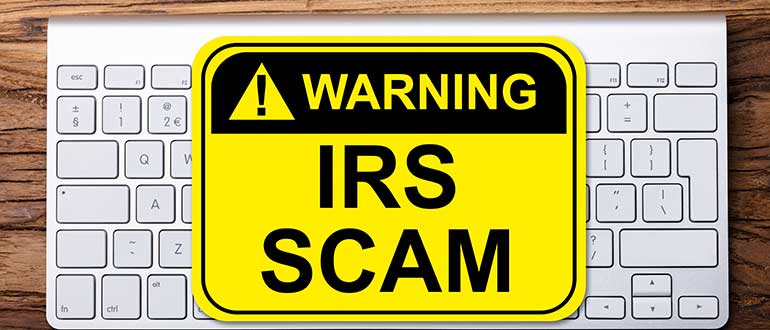 Elevated View Of IRS Scam Warning Sign On Keyboard